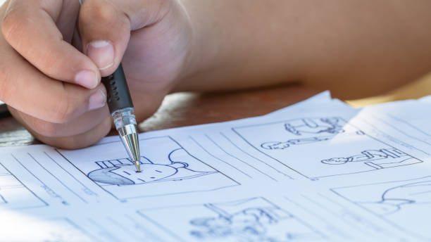 istock Hands drawing storyboard animation comic for pre-production process, design creative story scene layout in movie carton at studio. Behind making work before production film or video presentation 1186454443