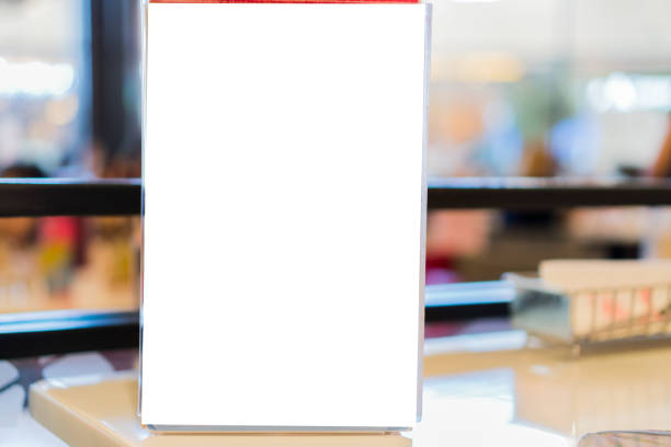 istock Blank mock up or label menu frame advertising in restaurant, Stand for booklets white paper sheets acrylic tent card on glass table in cafeteria, blurred background layout insert text for customer 1186456334