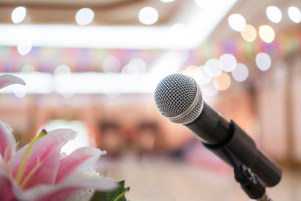 Seminar Conference Concept : Close-up Microphones on abstract blurred of speech in conference meeting room, front flowers speaking blur bokeh light in event convention hall in hotel background concepto de conferencia del seminario: micrófonos de primer plano sobre el punto de vista abstracto del habla en la sala de reuniones de la conferencia, flores frontales que hablan luz borrosa bokeh en el salón de convenciones de eventos en el fondo del