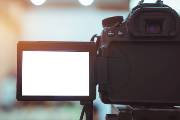 istock Video or professional digital dslr with blank lcd on tripod for camera recording taking photograph in production house or convention hall in live streaming event, media meeting  broadcast equipment. 1186456353