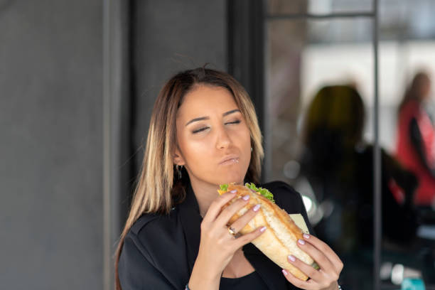 istock Cheerful woman eating a sandwich 1186466418