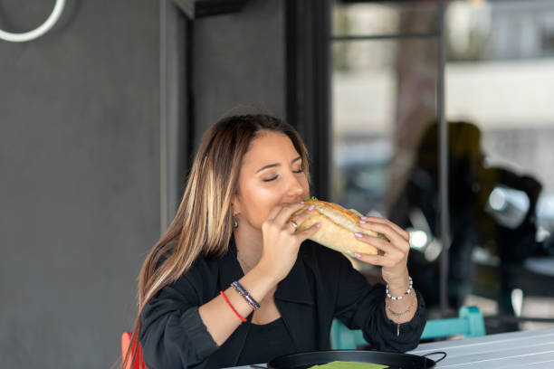 istock Cheerful woman eating a sandwich 1186467504