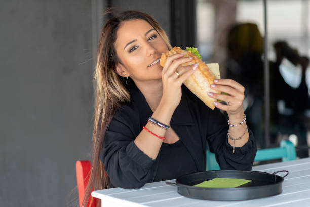 istock Cheerful woman eating a sandwich 1186467822