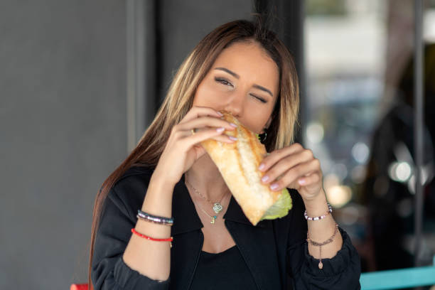istock Cheerful woman eating a sandwich 1186468051