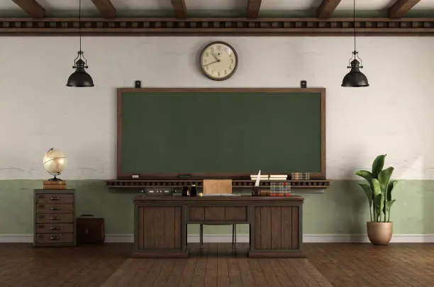 Photo of Retro style empty classroom with blackboard and desk teacher's desk