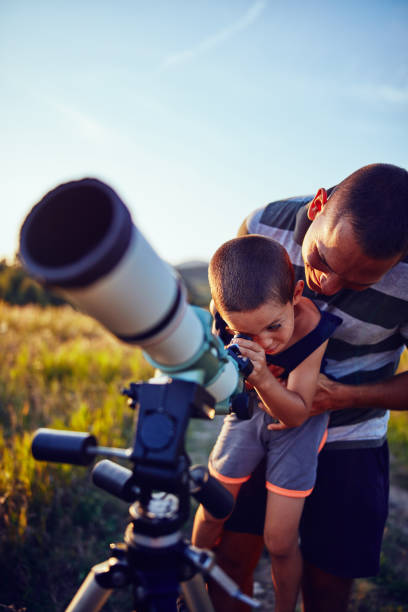 istock Father and son observing the sky with a telescope. 1186471085