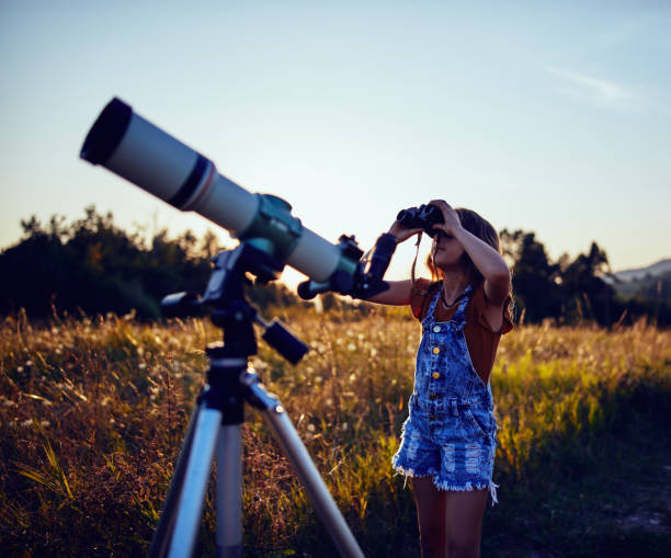 istock Little girl using telescope in nature to explore the universe. 1186472145