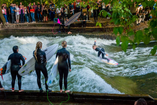 Munich, Germany - October 13, 2023: Surfer in the city river, Munich is famous for people surfing in urban enviroment called Eisbach