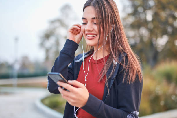 istock Modern young woman with cellphone making pause during jogging / exercise. 1186473284