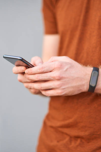 istock Young man using smartphone near a sloppy painted grey urban wall. 1186474426