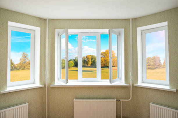 View through a opened modern PVC window onto beautiful autumn landscape