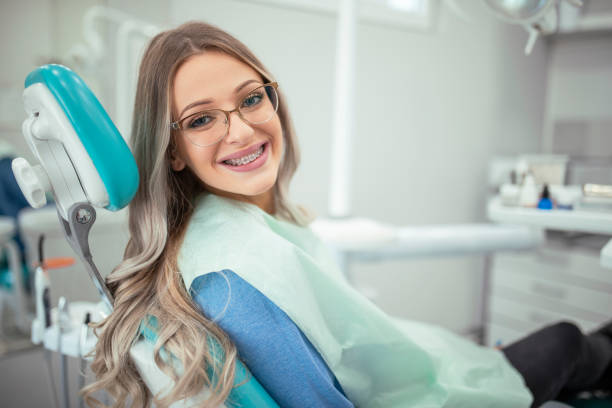 mujer con aparatos ortopédicos vino a ver al dentista para el examen - young women smiling women human teeth fotografías e imágenes de stock