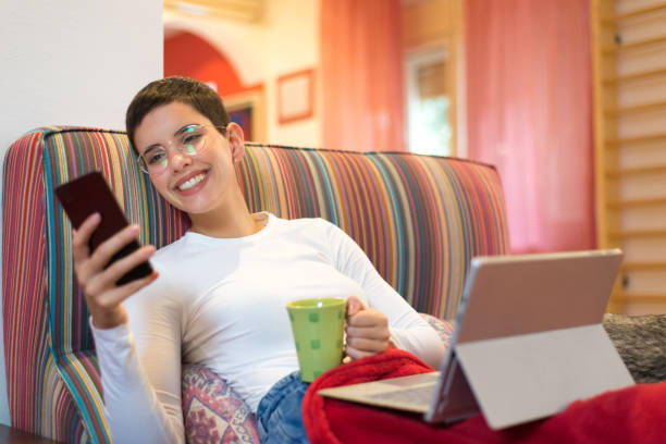 istock Young woman using smart phone at home 1186475637