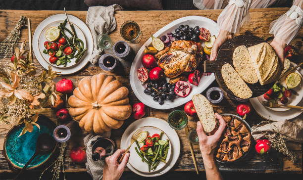 istock People eating festive dinner with roasted chicken on Thanksgiving day 1186475797