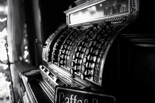 Imagen en blanco y negro de una antigua caja registradora del siglo XIX. Enfoque selectivo en los botones del cajero. photo