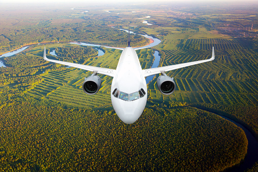 commercial airplane flying over the clouds