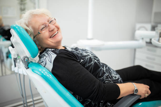 mulher idosa na cadeira do dentista que espera o tratamento de seus dentes - smiling dentist office dentists chair women - fotografias e filmes do acervo