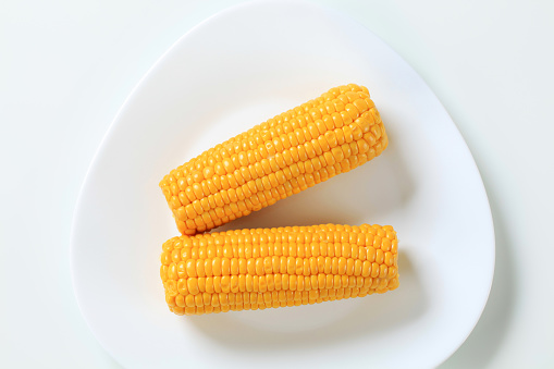 two boiled corn cobs on white plate