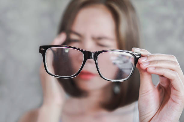 azjatka trzymająca okulary o bólu głowy z widzenia rozmycia oczu - eyewear store zdjęcia i obrazy z banku zdjęć