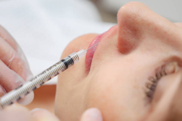 istock plastic surgeon injects filler to increase lips volume 1186483370