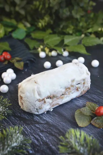 Photo of Full traditional German christmas season sweet food called 'Stollen' or 'Christstollen', a fruit bread of nuts, spices, and dried or candied fruit, coated with powdered sugar