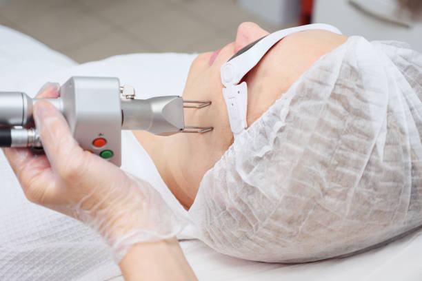 istock cosmetologist hand holds neodymium laser doing procedure 1186483487