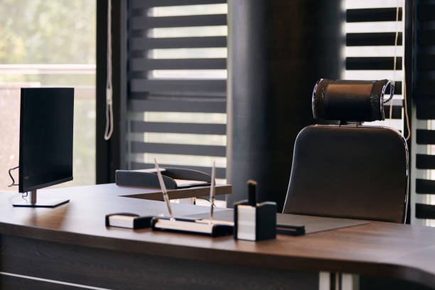 istock Business office workplace. Work place for chief, boss or other employees. Table and comfortable chair. Light through the half open blinds 1186484213