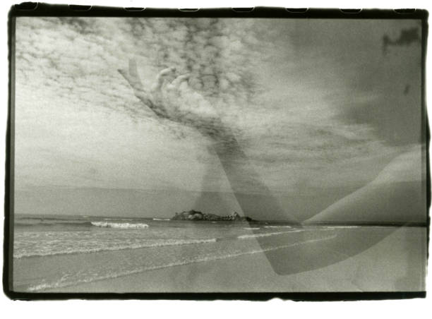 istock Graceful female hand and a seascape with clouds in one frame. 1186491096