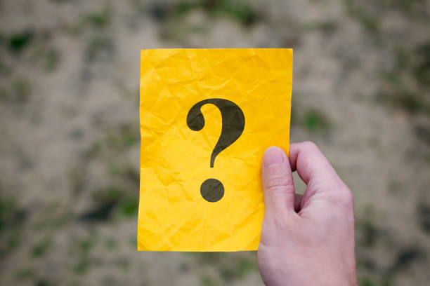 istock Man holding yellow paper note with Question mark in his hand 1186496707