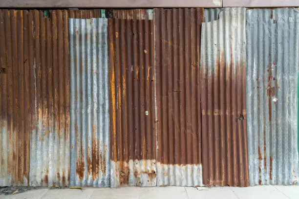 Photo of Rusted galvanized iron plate, red stain on old metal sheet wall texture.