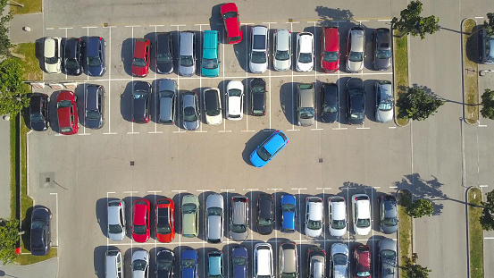 AERIAL TOP DOWN, HYPERLAPSE: Bad driver incapable to park a car on parking space in big crowded parking lot. Female having problems, unable to park a car in parking spot. Parking fail on parkspace
