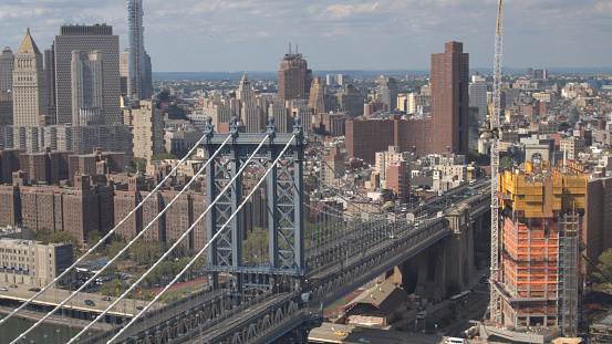 AERIAL CLOSE UP: Manhattan bridge highway connecting Brooklyn borough and downtown New York City business district. Flying above famous multiple lane expressway with cars, semi trucks driving in USA