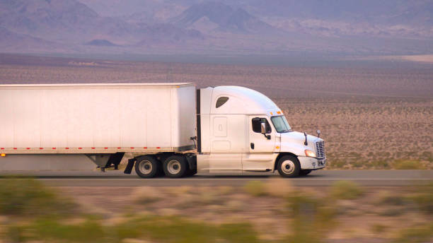close up: caminhão de carga semi condução e transporte de mercadorias na estrada vazia - truck close up fuel tanker semi truck - fotografias e filmes do acervo