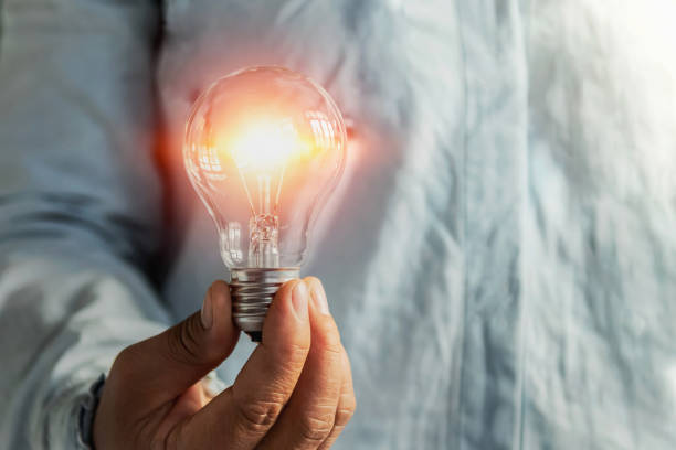 istock businessman hand holding lightbulb. idea Alternative energy concept saving electricity 1186508139
