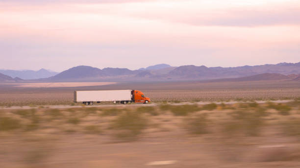 クローズアップ:貨物セミトラックの運転と交通量の多い高速道路上の商品の輸送 - fuel tanker close up semi truck multiple lane highway ストックフォトと画像