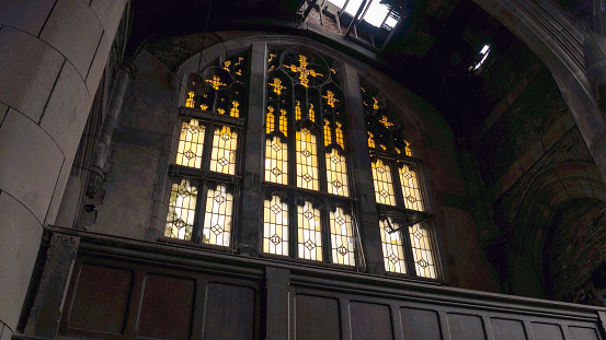 CLOSE UP: Majestic old gothic chapel in abandoned City Methodist Church, Gary Indiana, USA. Sun light coming through the broken roof and windows illuminating crumbling sanctuary in ruined cathedral