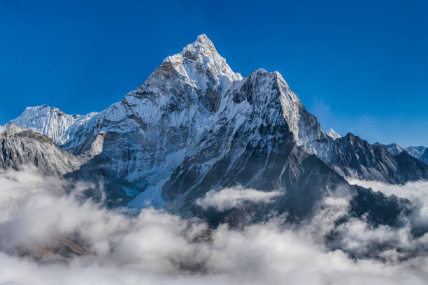 Panorama of beautiful  Mount Ama Dablam in  Himalayas, Nepal XXXXL size panorama of Mount Ama Dablam - probably the most beautiful peak in Himalayas. 
 This panoramic landscape is an very high resolution multi-frame composite and is suitable for large scale printing
Ama Dablam is a mountain in the Himalaya range of eastern Nepal. The main peak is 6,812  metres, the lower western peak is 5,563 metres. Ama Dablam means  'Mother's neclace'; the long ridges on each side like the arms of a mother (ama) protecting  her child, and the hanging glacier thought of as the dablam, the traditional double-pendant  containing pictures of the gods, worn by Sherpa women. For several days, Ama Dablam dominates  the eastern sky for anyone trekking to Mount Everest basecamp icefall stock pictures, royalty-free photos & images