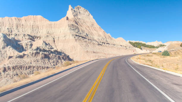istock FPV: Driving along the empty road winding through vast Badlands mountain desert 1186508628