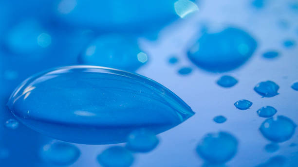 istock DOF, MACRO,CLOSE UP: Transparent reflecting raindrops shining on blue car's roof 1186508717