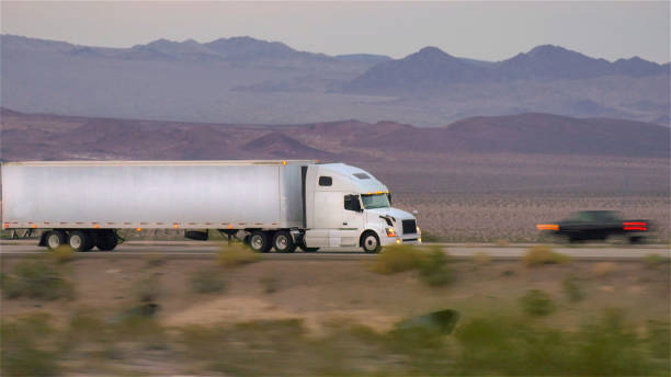 istock CLOSE UP: Freight semi truck driving and transporting goods on empty highway 1186509833