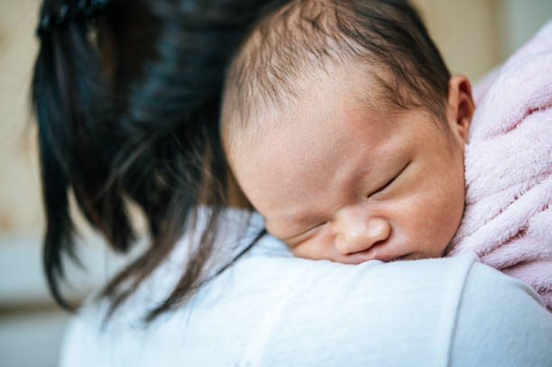 istock Newborn baby sleeping on the mother's shoulder. 1186510412