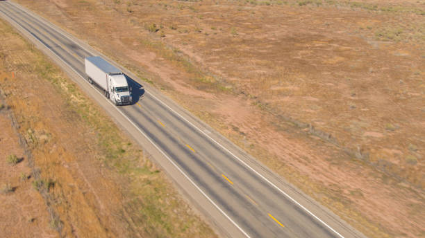 istock AERIAL: Clear white container truck transporting cargo along the empty motorway 1186510946