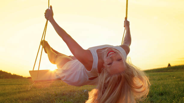 istock CLOSE UP: Joyous girl swinging in summer evening, smiling at camera. 1186512708