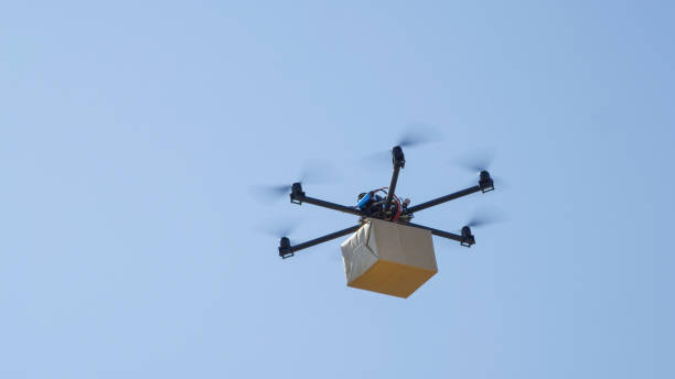 istock CLOSE UP: Drone delivery, multirotor helicopter flying big brown post package 1186513650