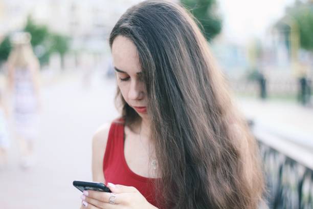 istock Young pretty girl's using smartphone with city on background 1186513880