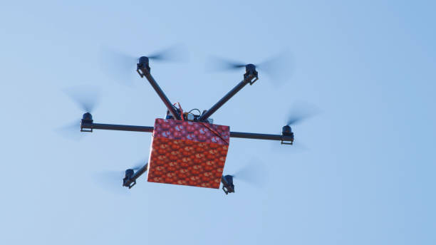 istock LENS FLARE: Delivery drone shipping Christmas present over the blue sunny sky 1186513990