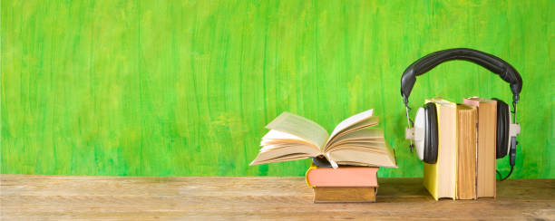 istock audio book concept with open book and headphones, panoramic format on grungy background, good copy space 1186516496