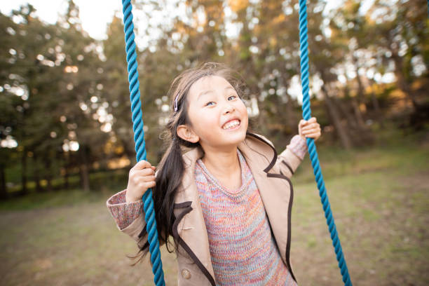 istock Smiling girl playing in autumn park 1186517353