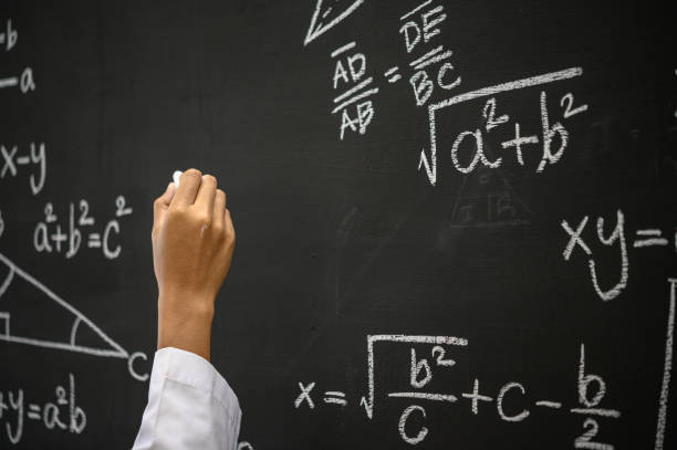 istock The hand that writes the formula with white chalk on the blackboard 1186518003