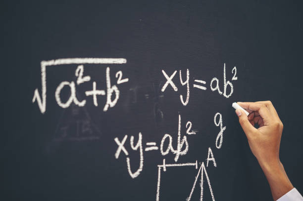 istock The hand that writes the formula with white chalk on the blackboard 1186518008